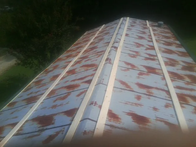 Rusted metal roof panels with new wood purlins before replacement — Storm Damage Roof Repair in Wells Tannery by Roofing Brothers