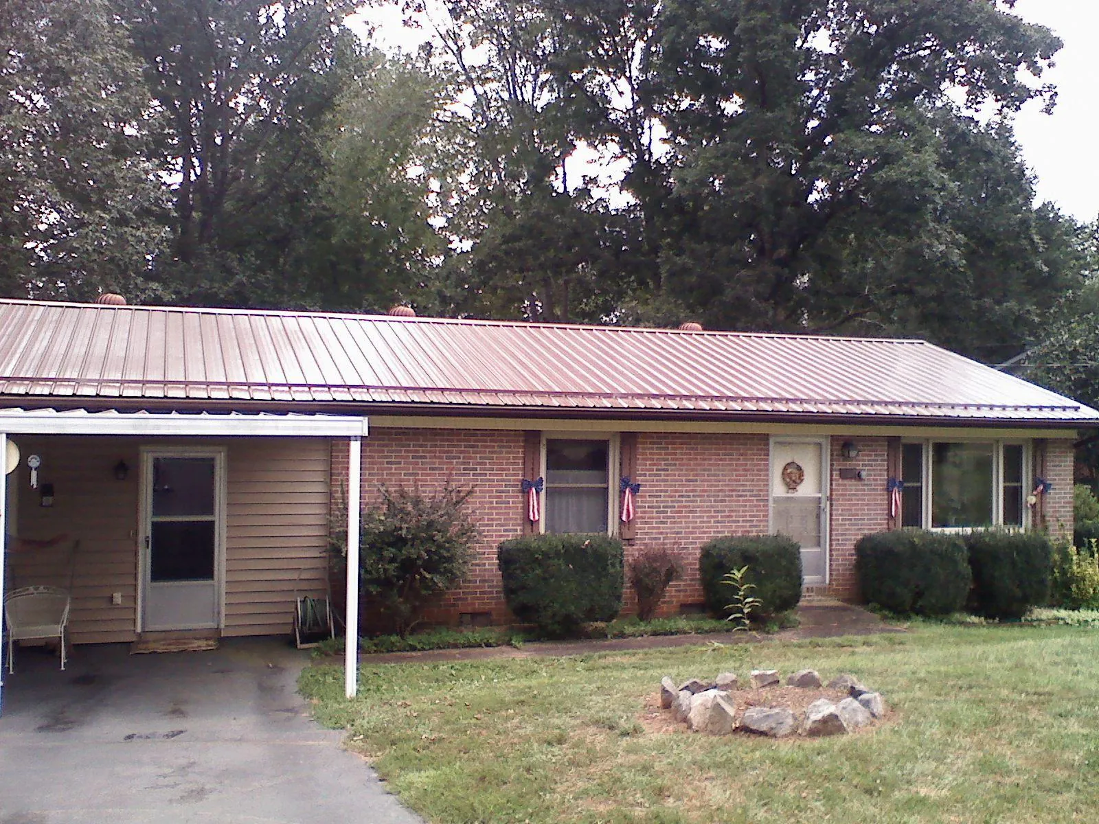 Bronze metal roof and carport on a brick ranch home — Roof Repair work by our crew in Wells Tannery